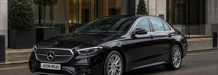 Jacob Miles Mercedes E-Class chauffeur vehicle parked outside a modern corporate office building in London
