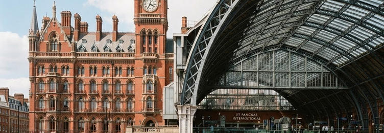 St Pancras International Station with the Gothic red brick Victorian hotel facade and iron arches in bright natural daylight
