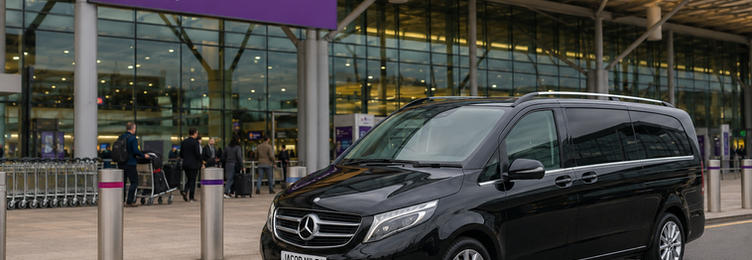 Black Mercedes-Benz V-Class chauffeur vehicle at Heathrow Terminal 5 departures drop-off