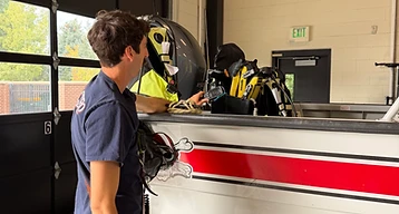 South Metro Fire Rescue first responder working near a rescue boat on a trailer inside a fire station.