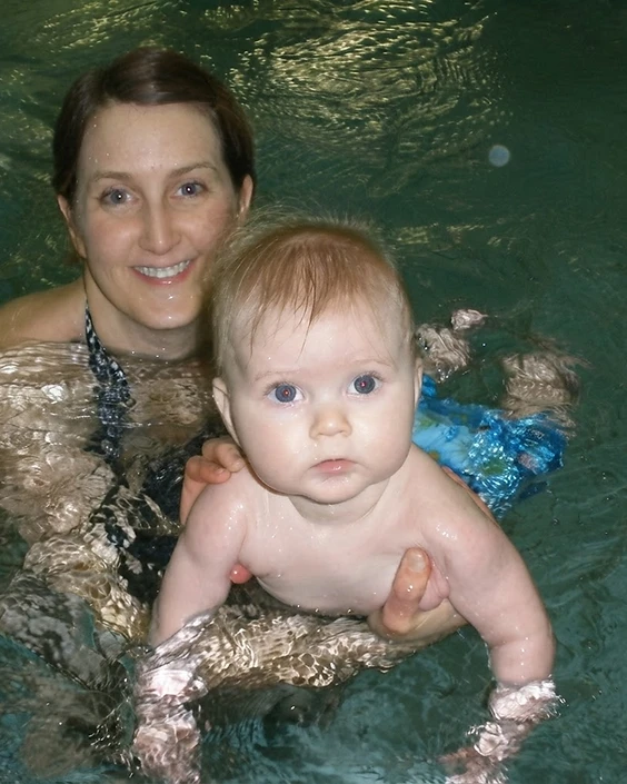 A mother holding her five-month-old child in the water