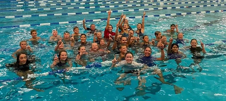 Colorado Aquatics Foundation swimmers and coaches celebrating together in the pool