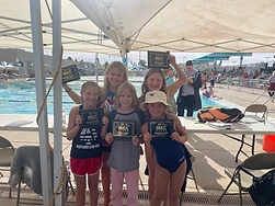 Five young swimmers smiling and holding their USA Swimming IMX Games award plaques