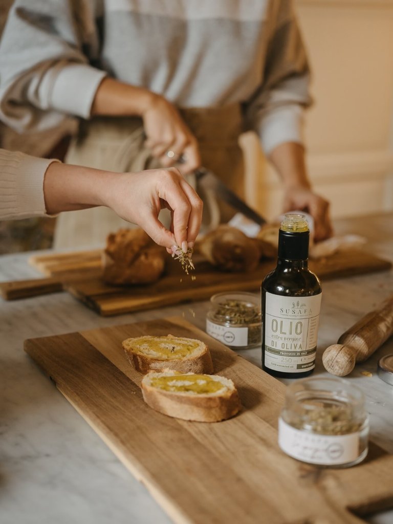 Drizzling olive oil over rustic bread