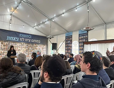 Students gathered inside a lit tent for a campus event