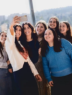 Students taking a selfie on a balcony overlooking Jerusalem