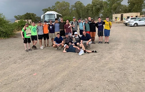 International Program students gathered on a gravel lot before a trip