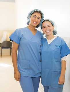 Nursing students in scrubs smiling during clinical training