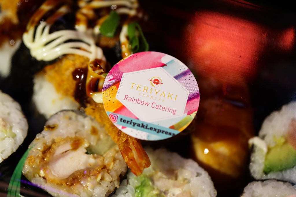 Individual sushi bento box with teriyaki prawn and salmon rolls