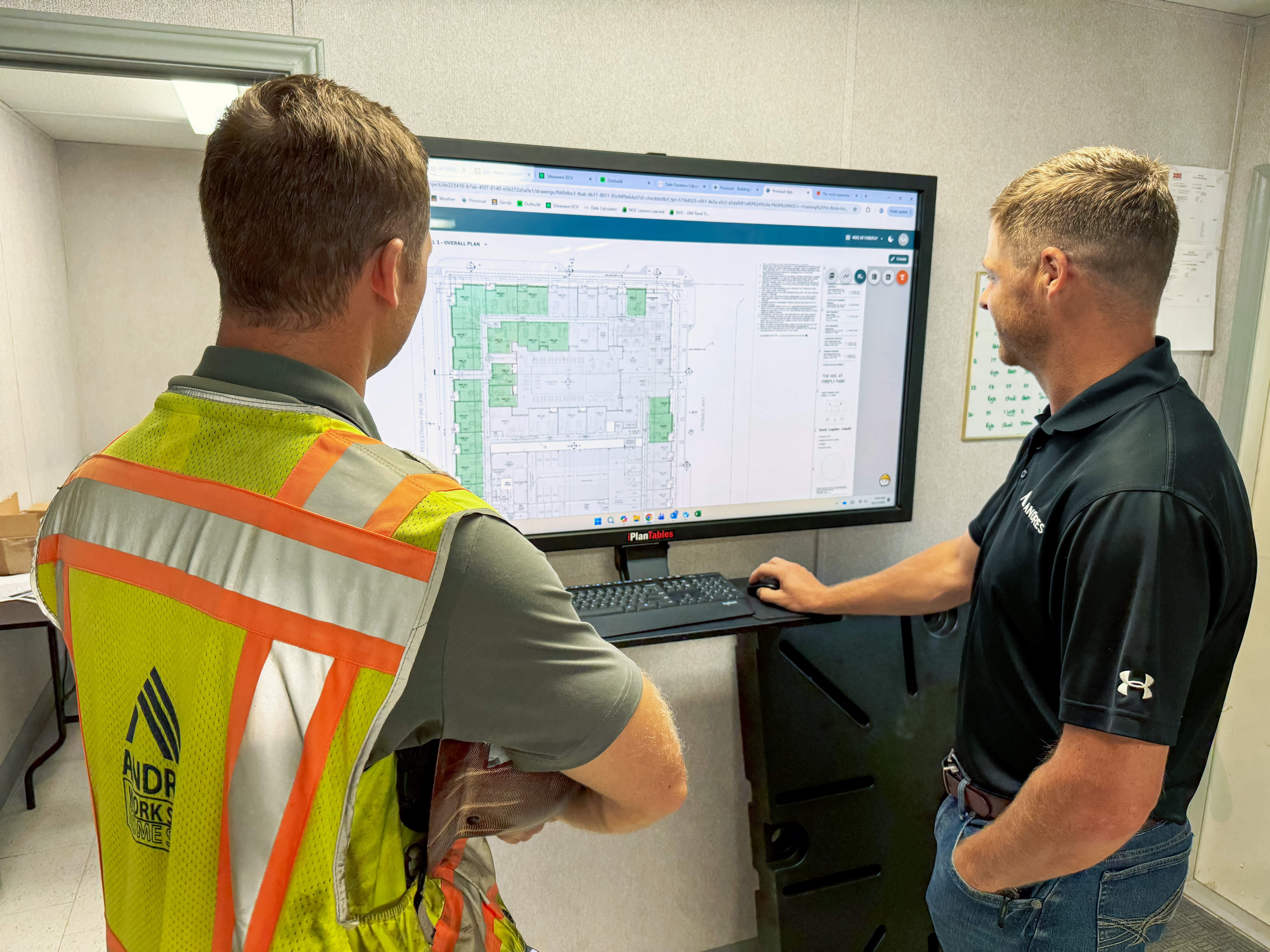 Superintendent reviewing plans on a tablet at a jobsite