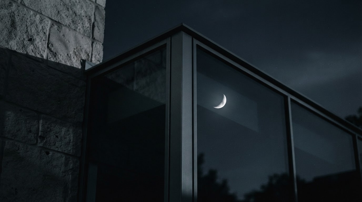 A glass corner and steel beam of The Meridian House in moonlight