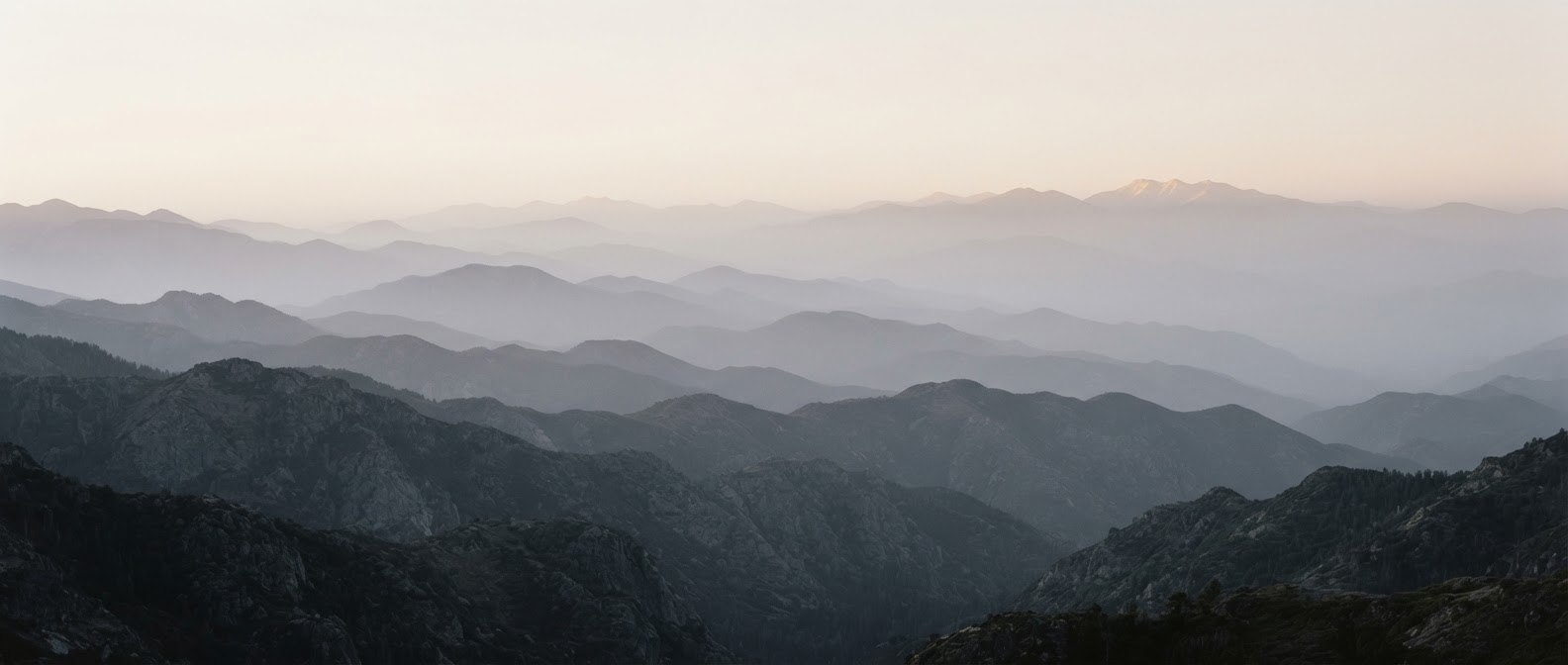 Layered mountain ranges fading into misty atmospheric haze