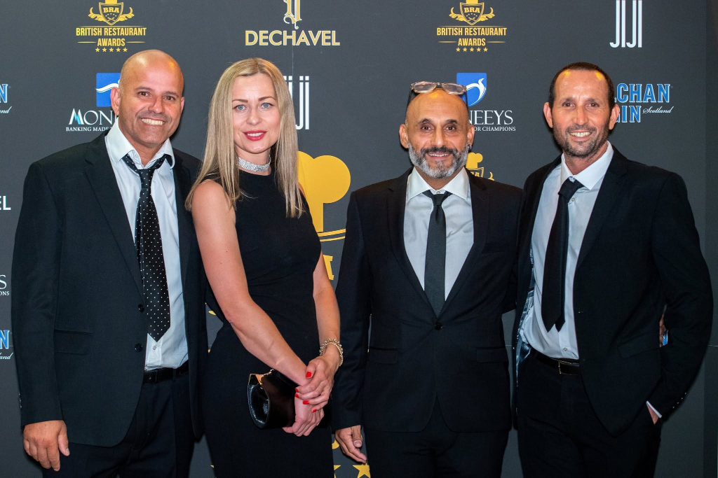 Guests attending the British Restaurant Awards ceremony in front of the branded backdrop
