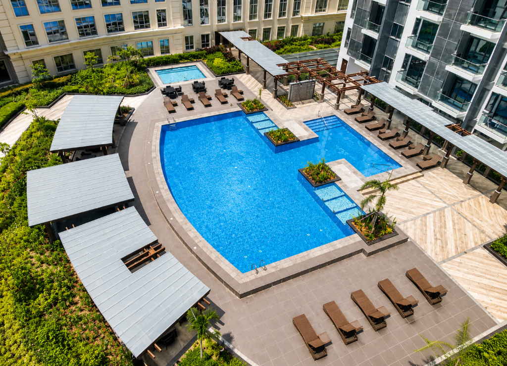 Swimming pool area at Newport City condominium with turquoise water and lounge chairs