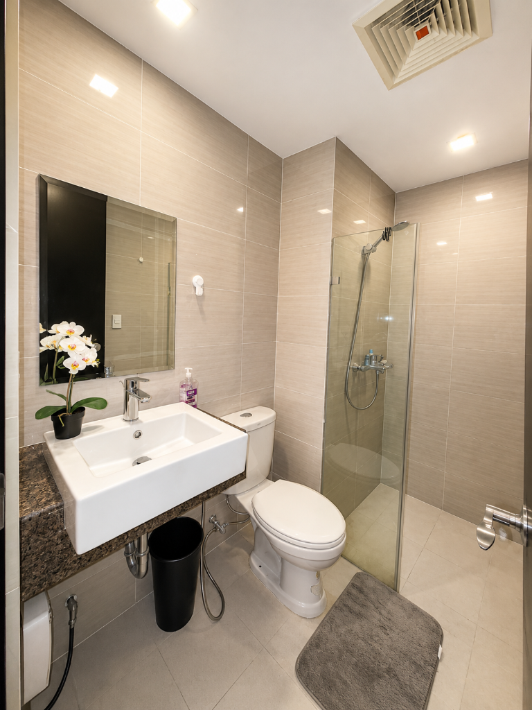 Bathroom with square vessel sink, glass shower enclosure, granite vanity, and orchid accent