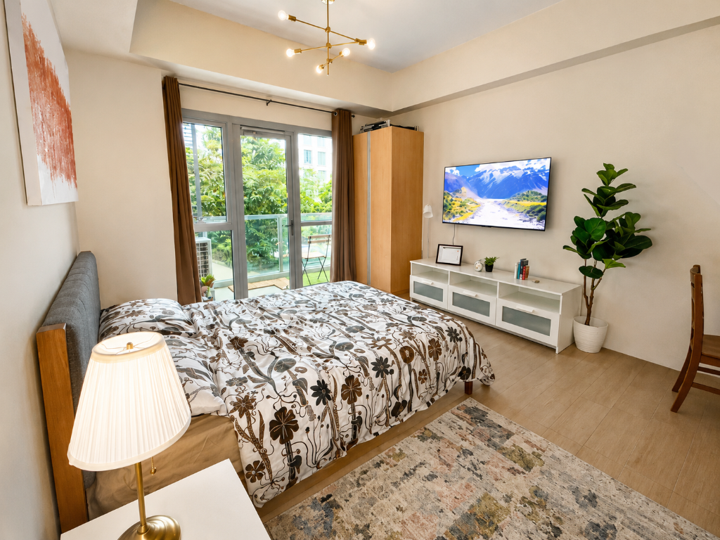 Briana's Haven Two — bedroom with floral duvet, balcony garden view, smart TV, and warm brass lighting at 81 Newport Boulevard