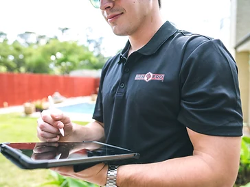 GenPro electrician using a stylus to fill out an inspection report on a tablet at a Houston home