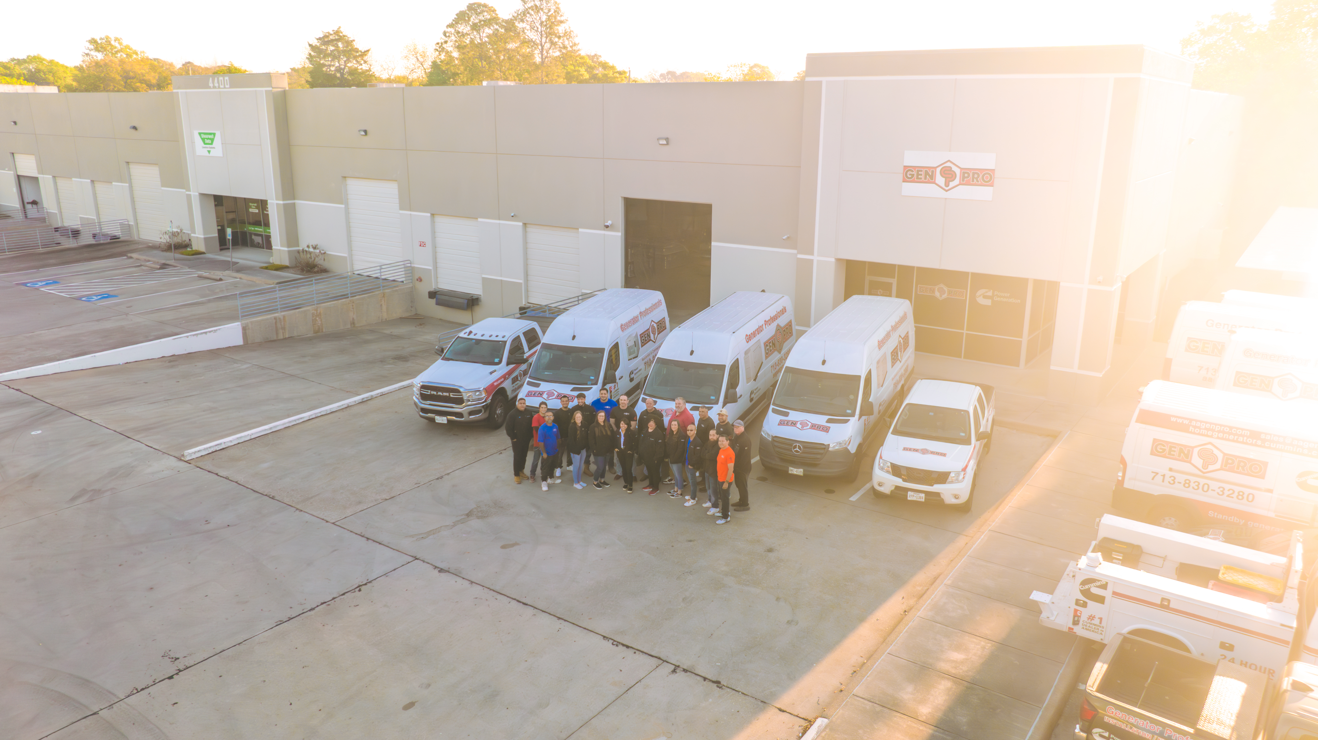 A&A GenPro installation team standing with the branded fleet of service vans and trucks at the GenPro facility