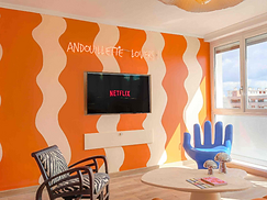 Séjour avec sofa orange et TV