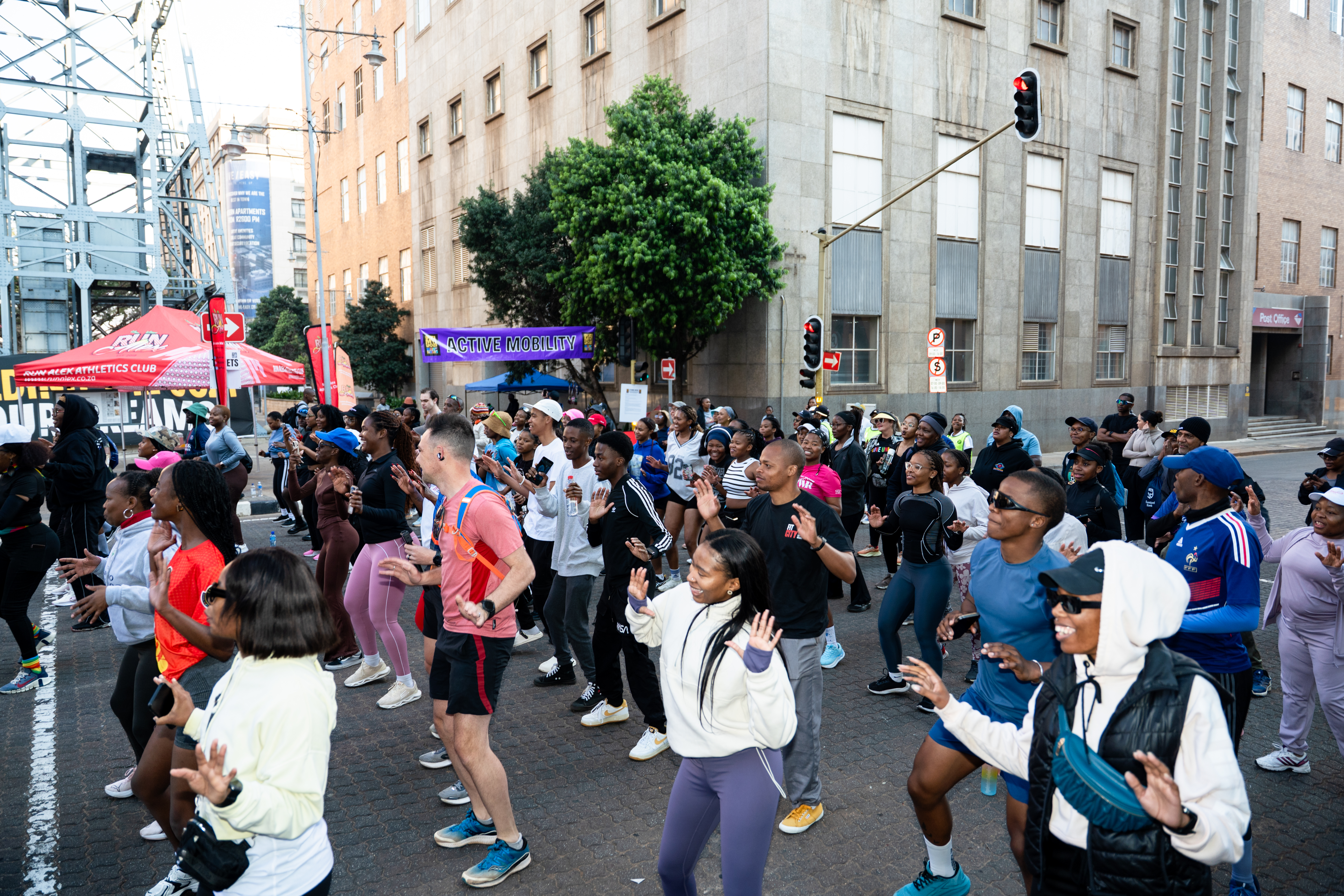 A large crowd taking part in an outdoor street fitness class in Johannesburg