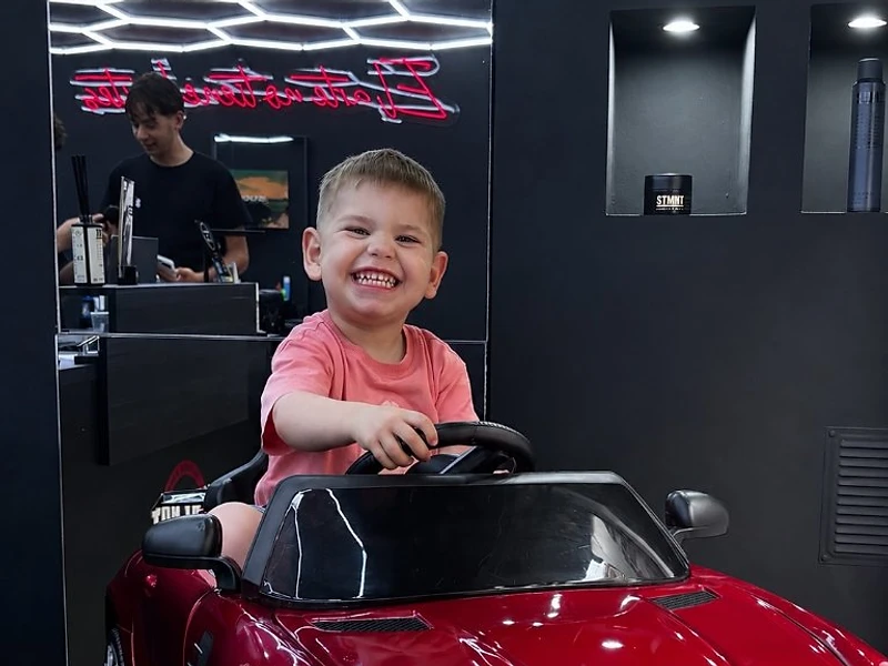 Peluquería infantil Barcelona — niño en coche Mercedes-Benz de Why Not Barbershop
