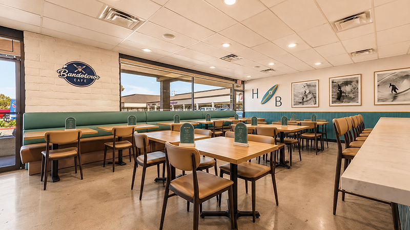 Hospitality interior design by Studio Fridae — Bandoleros Café in Huntington Beach, CA with teal wainscoting, HB surfboard wall art, and tan leather booth seating