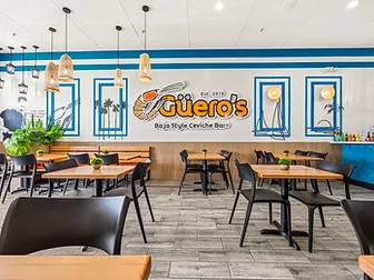 Mariscos El Güero wide shot of the dining room with bench seating and pendant lights — hospitality interior design in San Bernardino, CA by Studio Fridae