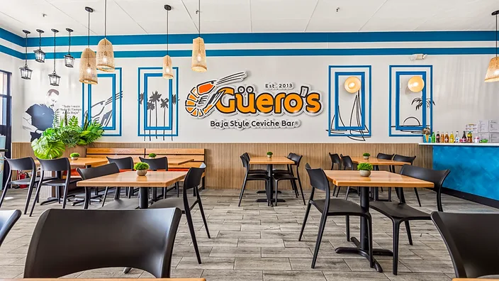 Mariscos El Güero wide shot of the dining room with bench seating and pendant lights — hospitality interior design in San Bernardino, CA by Studio Fridae