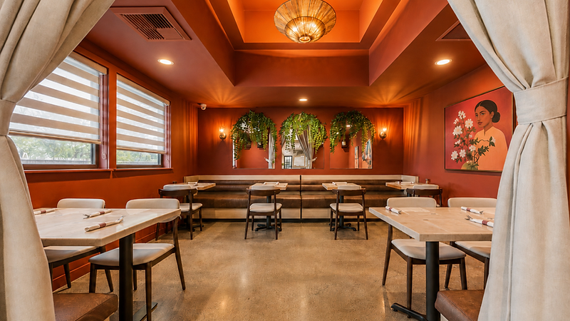 Hospitality interior design by Studio Fridae — Bandoleros Cafe in Cypress, CA dining room with brown leather banquette, hanging greenery, floral portrait, and terracotta ceiling