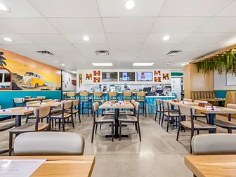 Bandoleros Café wide dining room with VW bus beach mural and teal wainscoting — hospitality interior design in Huntington Beach, CA by Studio Fridae