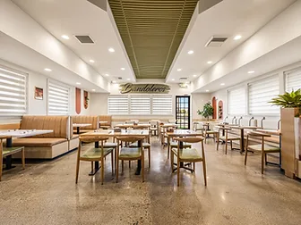 Bandoleros Cafe dining room in Cypress, CA with polished concrete aggregate flooring, tufted leather booths, and olive-green corrugated ceiling — restaurant flooring interior design by STUDIO FRIDAE