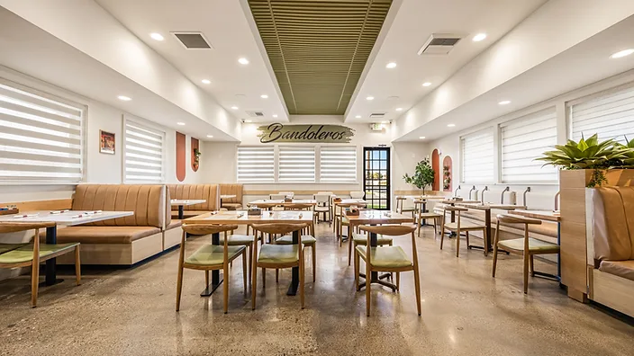 Bandoleros Cafe dining room in Cypress, CA with polished concrete aggregate flooring, tufted leather booths, and olive-green corrugated ceiling — restaurant flooring interior design by STUDIO FRIDAE