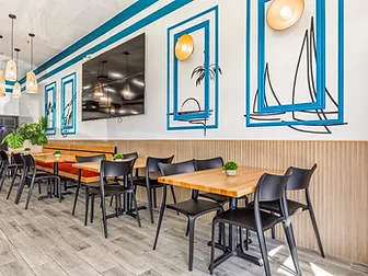 Mariscos El Güero banquette seating with burnt-orange cushions — hospitality interior design in San Bernardino, CA by Studio Fridae, an example of finish level in full-service design