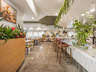 Bandoleros Cafe bar and dining area in Cypress, CA with marble counter, trailing greenery canopy, and desert art prints — restaurant interior design ideas by STUDIO FRIDAE