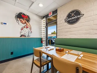 Hospitality interior design by Studio Fridae — Bandoleros Café in Huntington Beach, CA with floral mural, teal wainscoting, and sage green booth seating