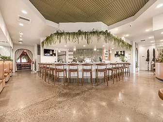 Bandoleros Cafe main dining area in Cypress, CA with hexagonal service bar, hanging greenery installation, and brown leather bar stools — restaurant interior design cost example by STUDIO FRIDAE