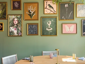 Flora dining room with botanical gallery wall and round oak table — hospitality interior design in Charlotte, NC by Studio Fridae