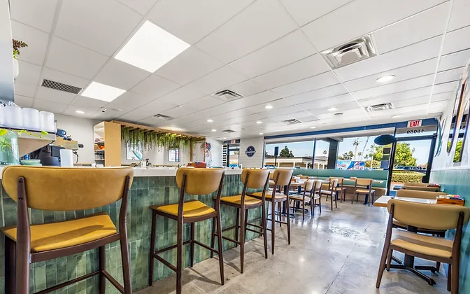 Bandoleros Café — sage green banquette seating with warm pendant lighting — hospitality interior design in Huntington Beach, CA by Studio Fridae