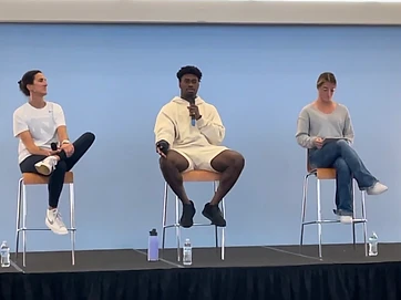 Elijah Green speaking on a panel on stage with fellow presenters
