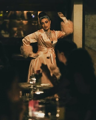 Burlesque performer in a champagne satin robe at Saint Tuesday