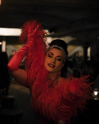 Burlesque performer with a red feather boa at Saint Tuesday