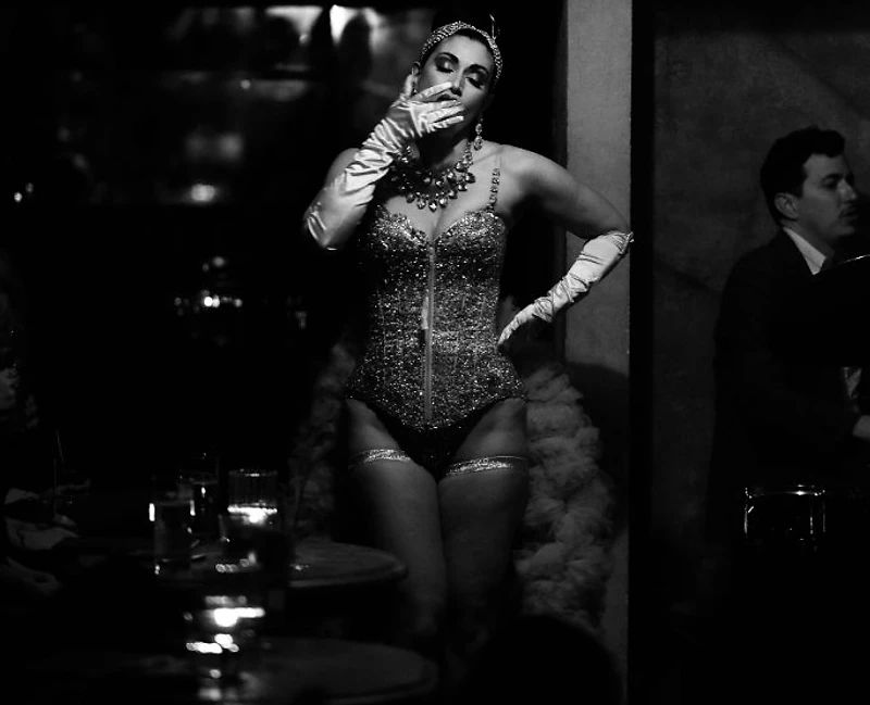A burlesque performer under candlelight inside the speakeasy at Saint Tuesday, Tribeca NYC