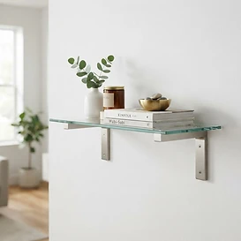 Solid brass shelf brackets supporting a glass shelf