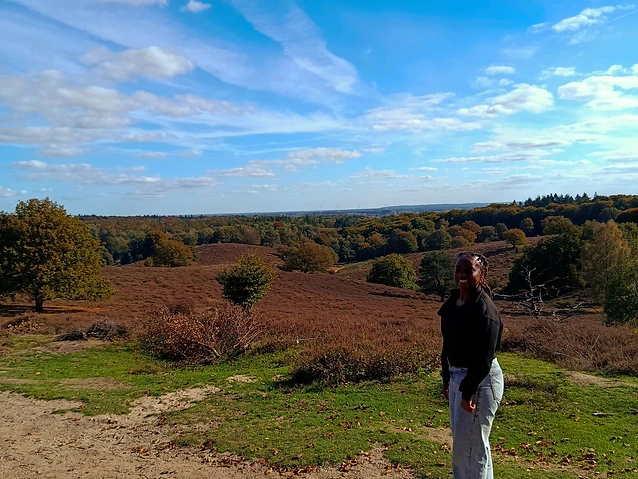 The author stands on a dirt path overlooking a vast, hilly landscape.
