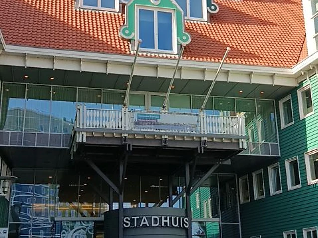The author approaches the Stadhuis entrance framed by contemporary glass and historical architectural elements.