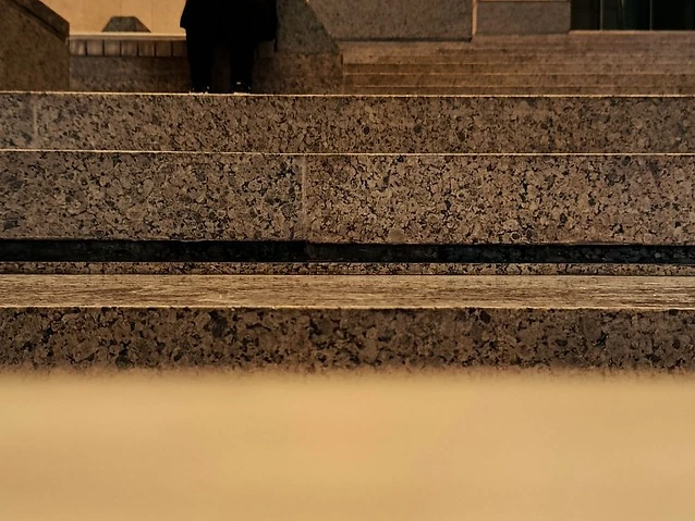 The observer sits on the monumental staircase, framed by statues and interior stone architecture.