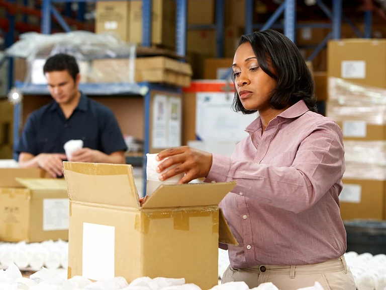 A worker packing goods in a warehouse