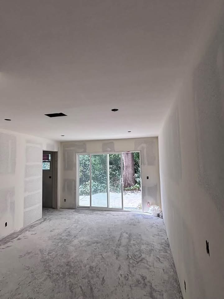 ADU interior looking toward sliding glass door with unfinished drywall