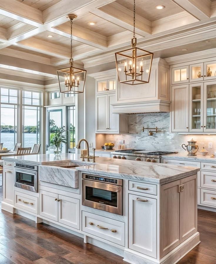 Light wood kitchen with marble waterfall island, square lantern pendants, and coffered ceiling