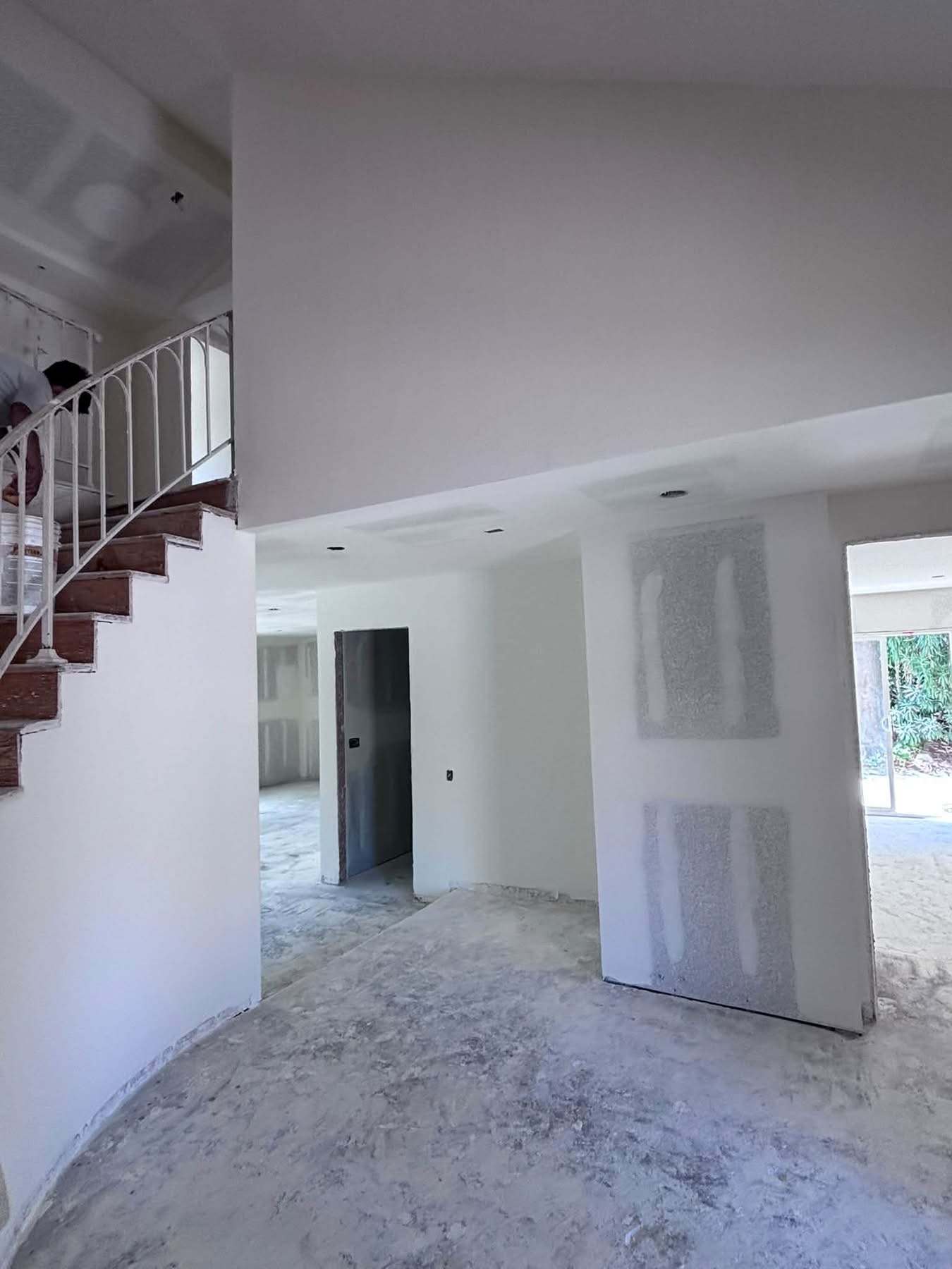 ADU interior with vaulted ceiling, open-riser staircase, and drywall in progress